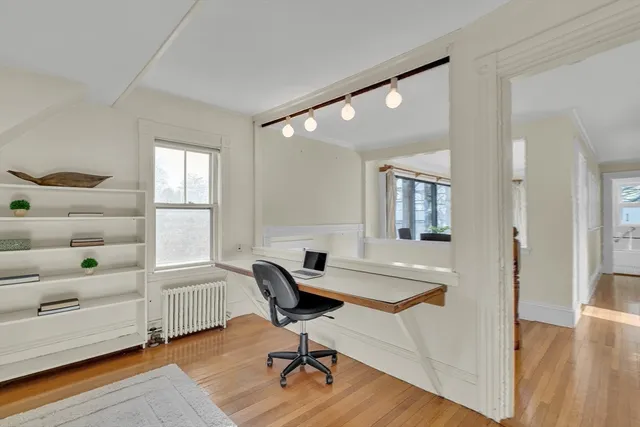 a view of a workspace with furniture and a window