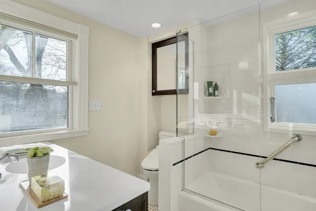 a bathroom with a tub sink and mirror