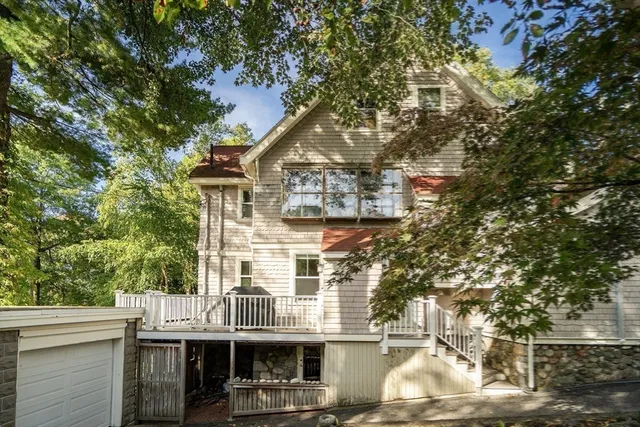 a view of a house with a tree in front of it