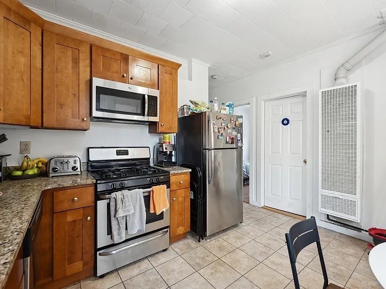 a kitchen with stainless steel appliances granite countertop a stove a refrigerator and a cabinets