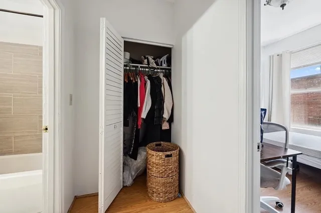a view of walk in closet with clothes and shoes
