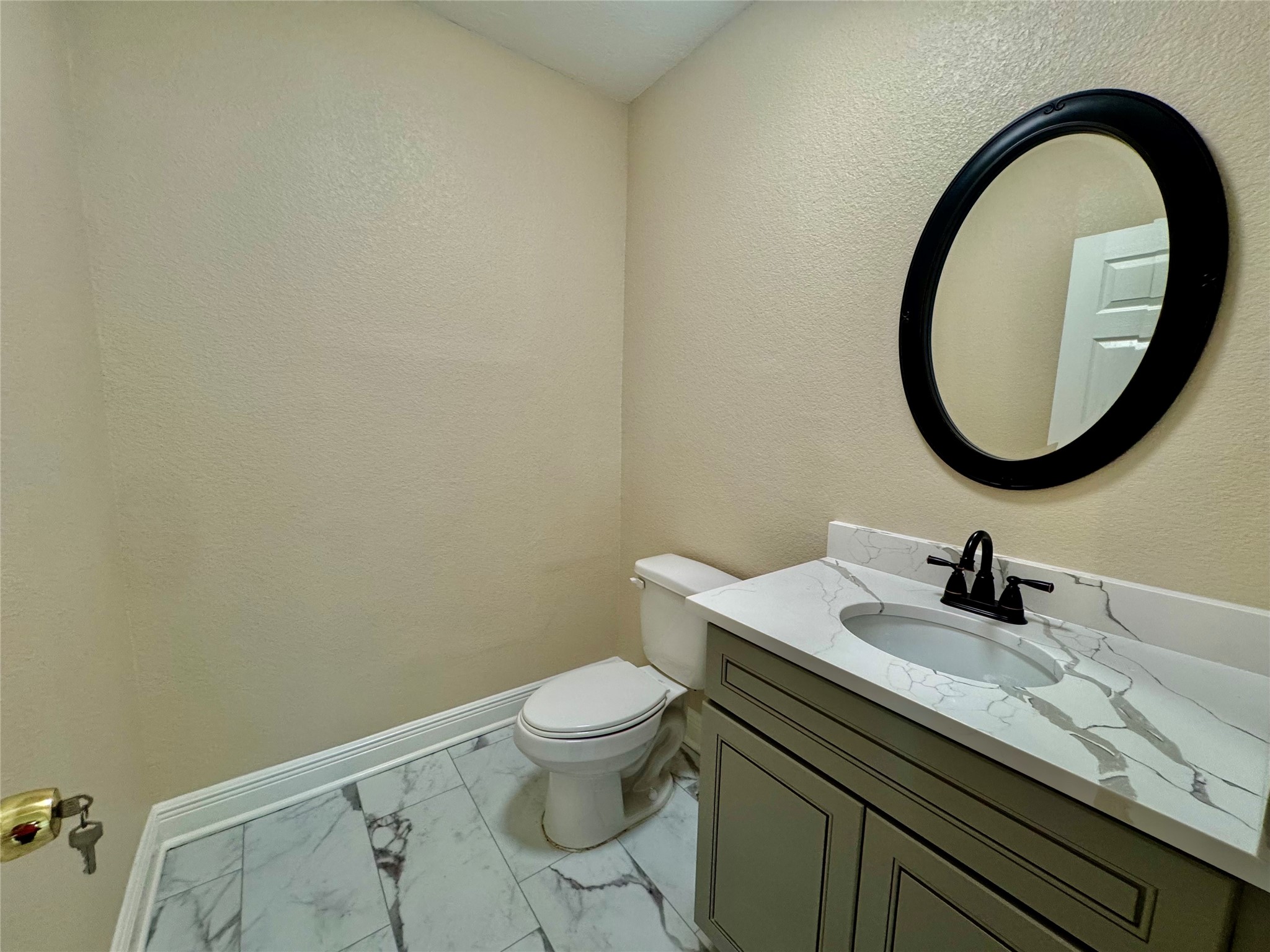 6645 Lodge Street Houston, TX 77092 - Photo 9 of 9 a bathroom with a granite countertop toilet a sink and a mirror