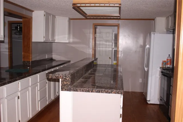 a kitchen with stainless steel appliances granite countertop a refrigerator and a stove