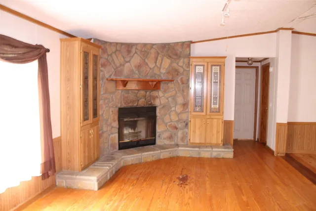 a view of an empty room with window and fire place
