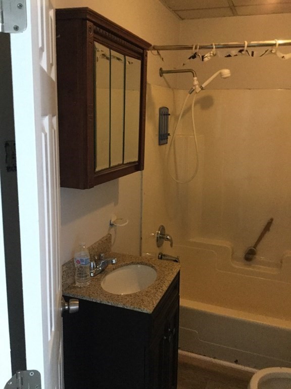 946 Rodman Street Fall River, MA 02721 - Photo 3 of 18 a bathroom with a granite countertop sink a mirror and shower