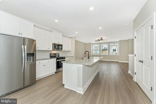 a kitchen with white cabinets and stainless steel appliances