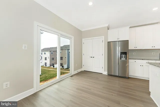 a view of kitchen with refrigerator wooden floor and window