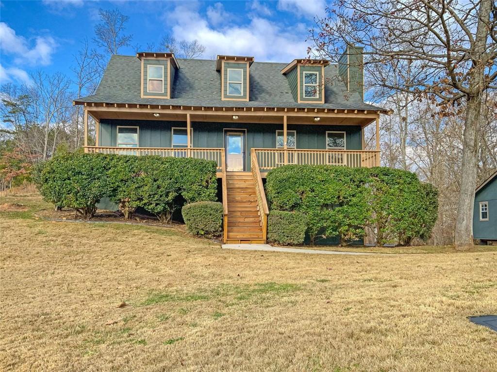 a view of a house with large windows and a yard with plants