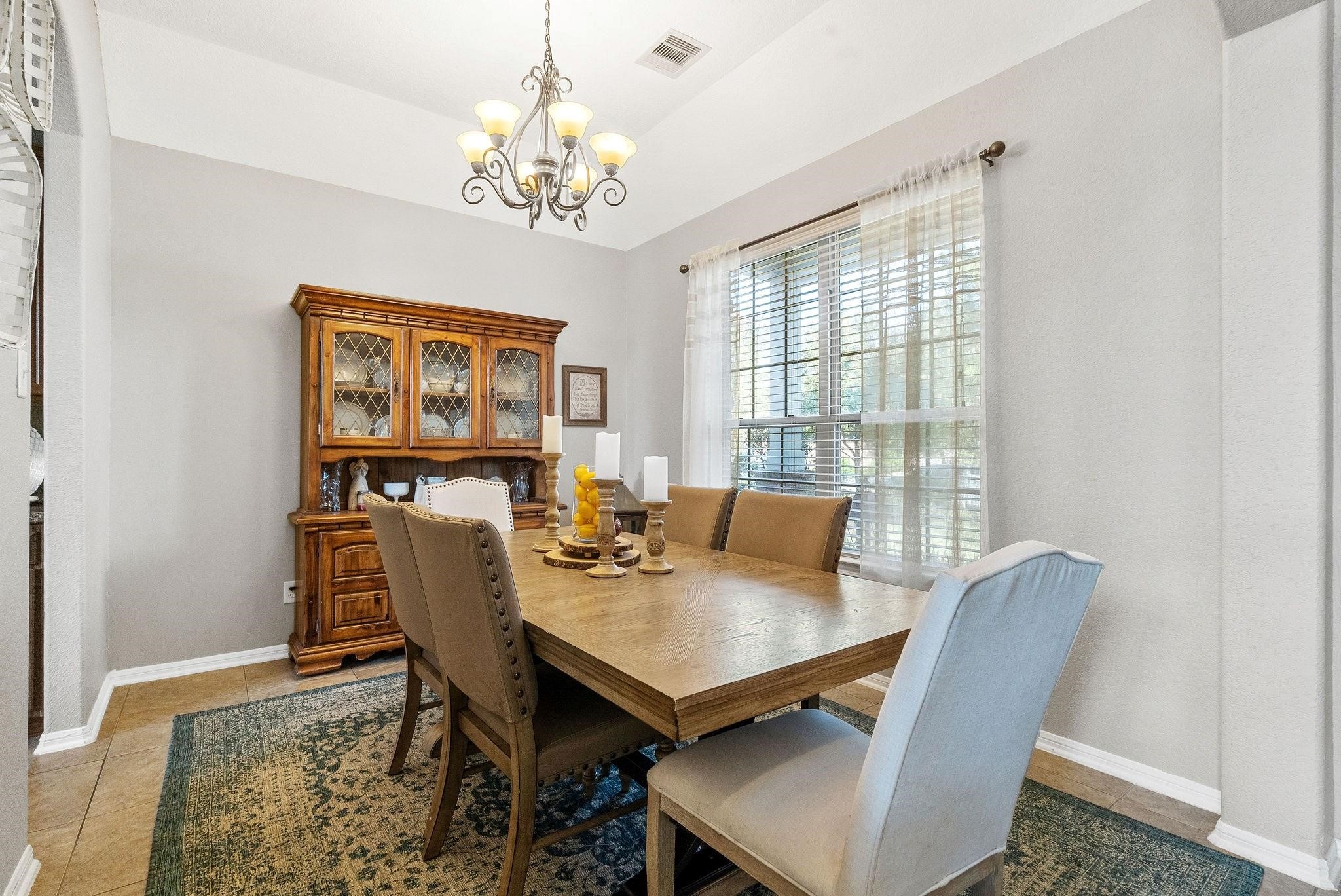 62 West Lasting Spring Circle The Woodlands, TX 77389 - Photo 11 of 46 a view of a dining room with furniture a chandelier and wooden floor