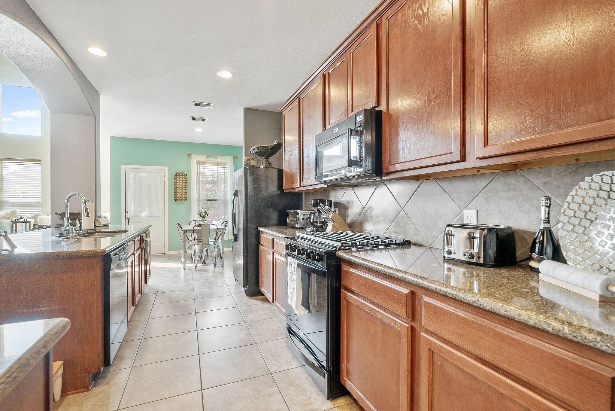 62 West Lasting Spring Circle The Woodlands, TX 77389 - Photo 15 of 46 a kitchen with stainless steel appliances granite countertop a sink and cabinets