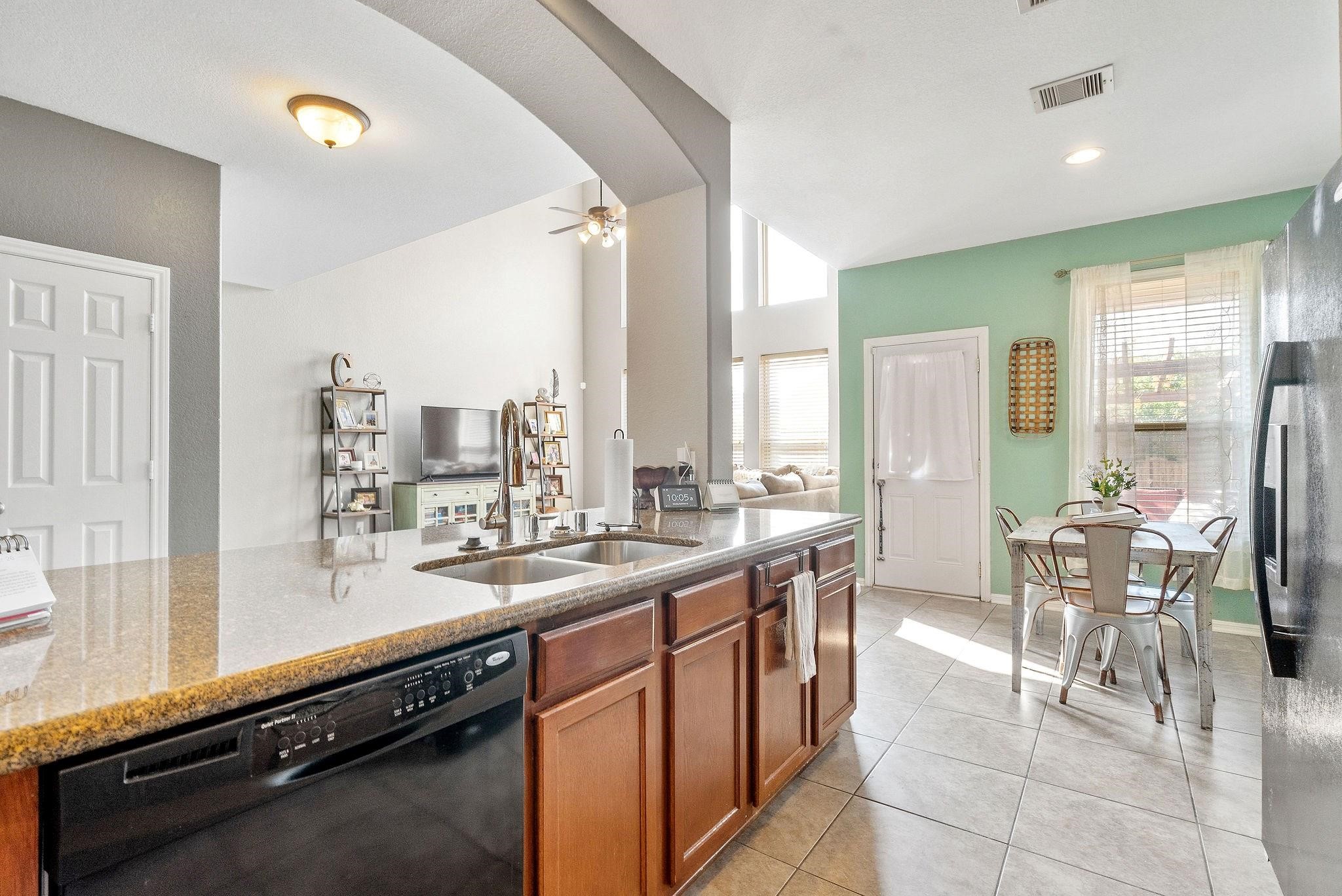 62 West Lasting Spring Circle The Woodlands, TX 77389 - Photo 16 of 46 a open dining room with stainless steel appliances kitchen island granite countertop a sink and chairs