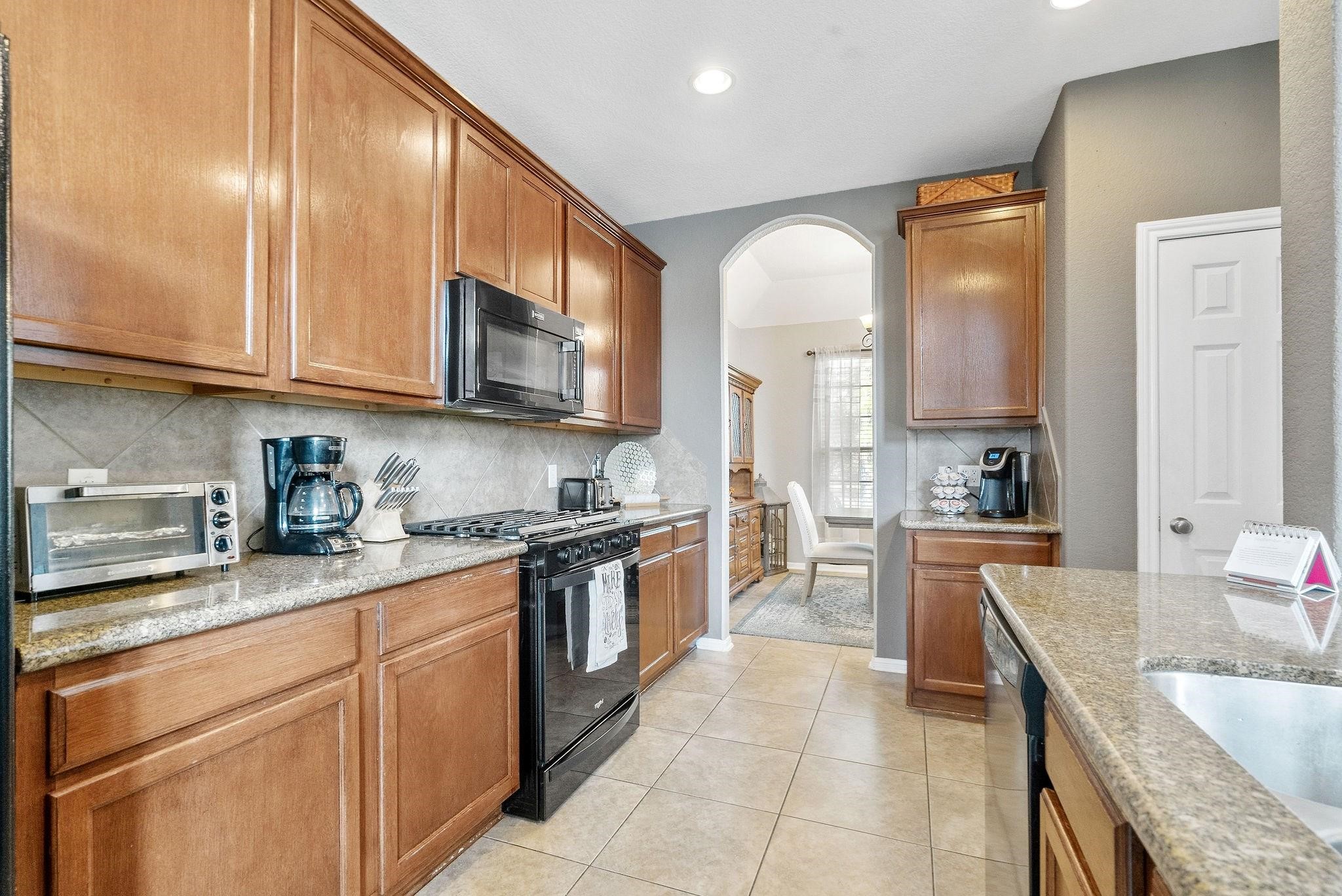 62 West Lasting Spring Circle The Woodlands, TX 77389 - Photo 17 of 46 a kitchen with stainless steel appliances granite countertop a stove sink and cabinets