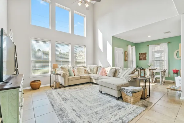 a living room with furniture a clock on wall and a table
