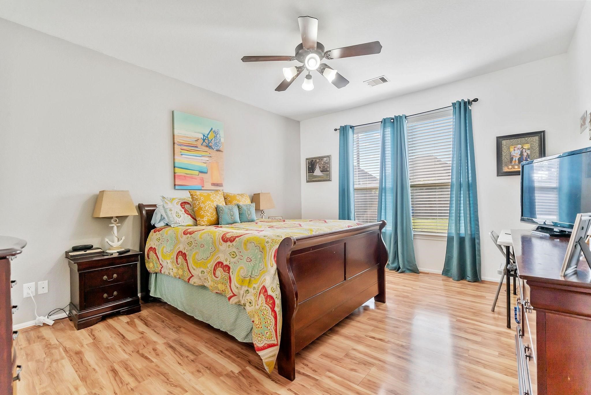 62 West Lasting Spring Circle The Woodlands, TX 77389 - Photo 27 of 46 a bedroom with a bed and a chandelier