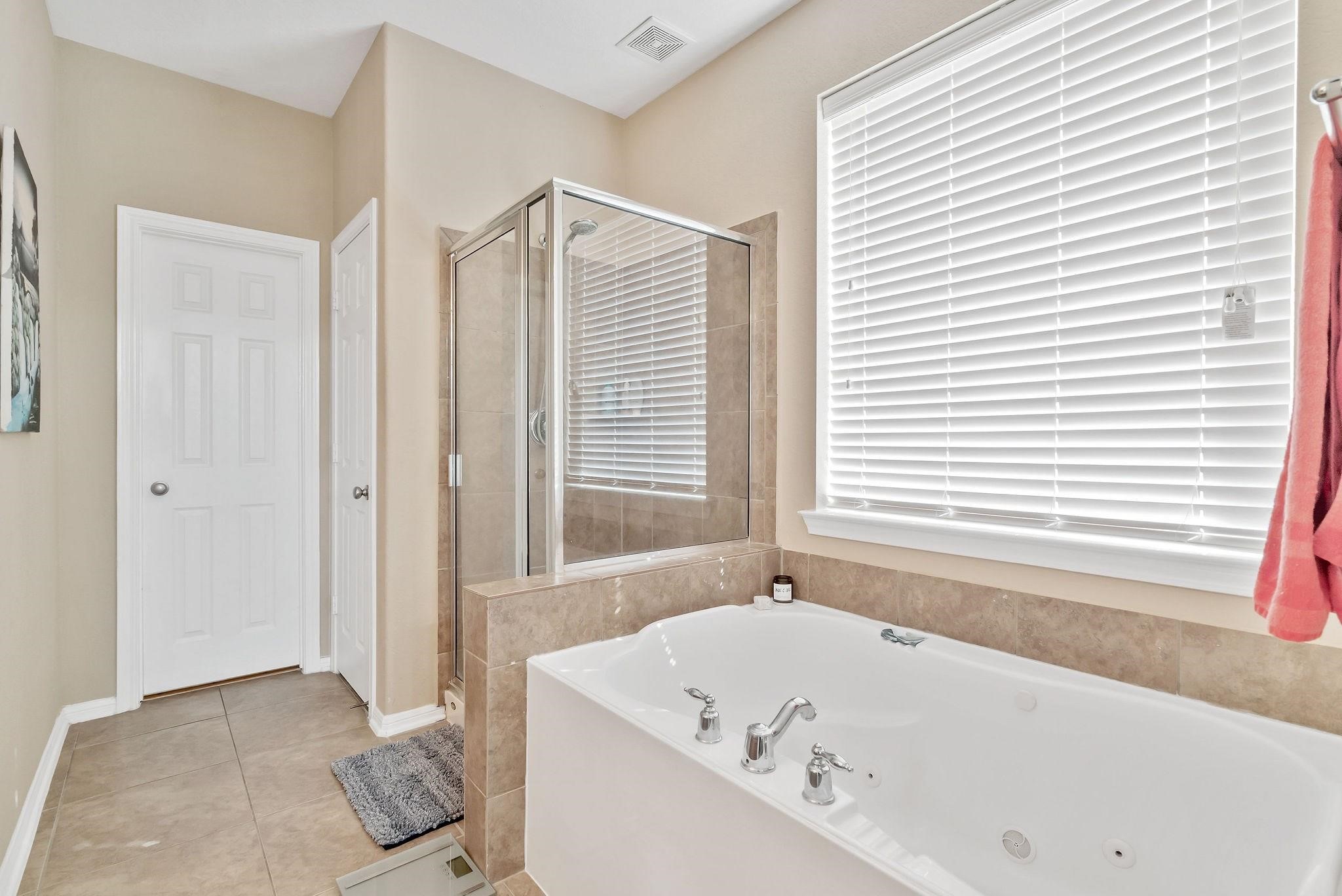 62 West Lasting Spring Circle The Woodlands, TX 77389 - Photo 30 of 46 a bathroom with a bathtub and a shower