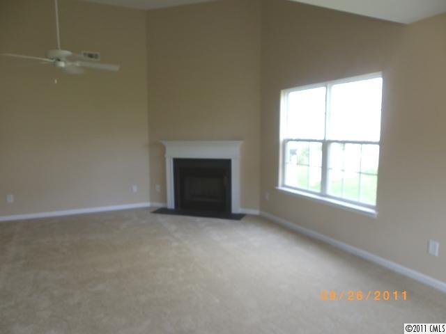 2766 Rustic Ridge Court Rock Hill, SC 29730 - Photo 2 of 13 an empty room with a fireplace and windows