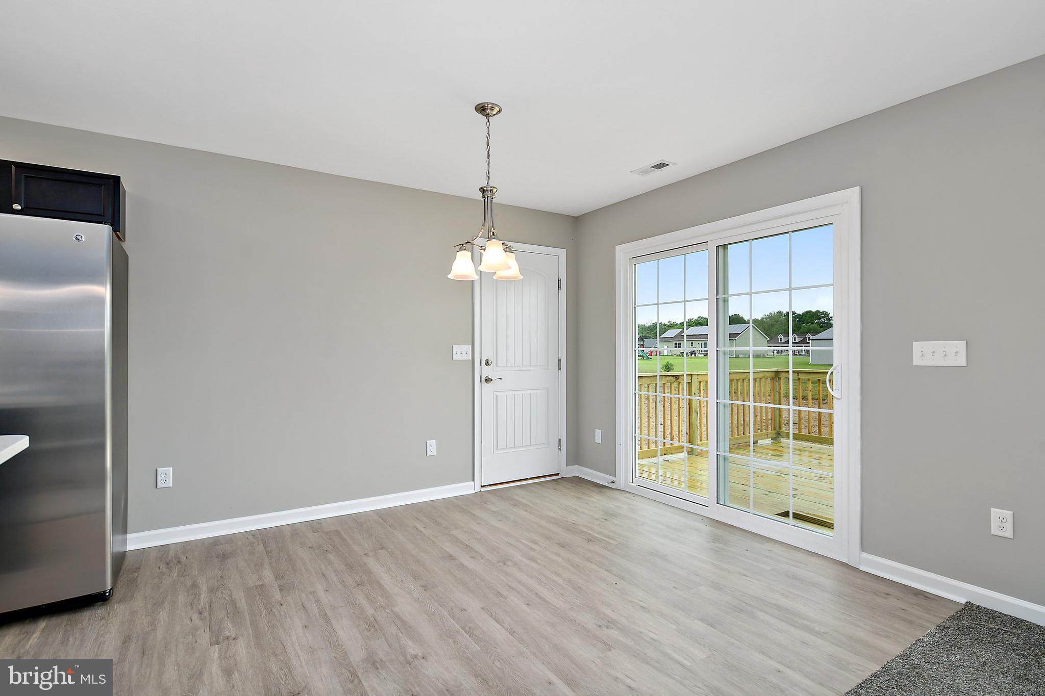 153 Fooks Road Bishopville, MD 21813 - Photo 13 of 30 a view of an empty room with wooden floor and a window
