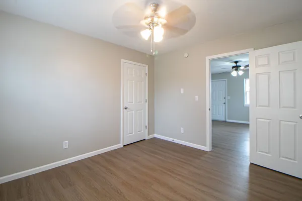 a view of an empty room with wooden floor