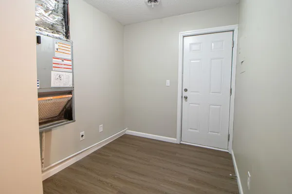 an empty room with wooden floor and mirror
