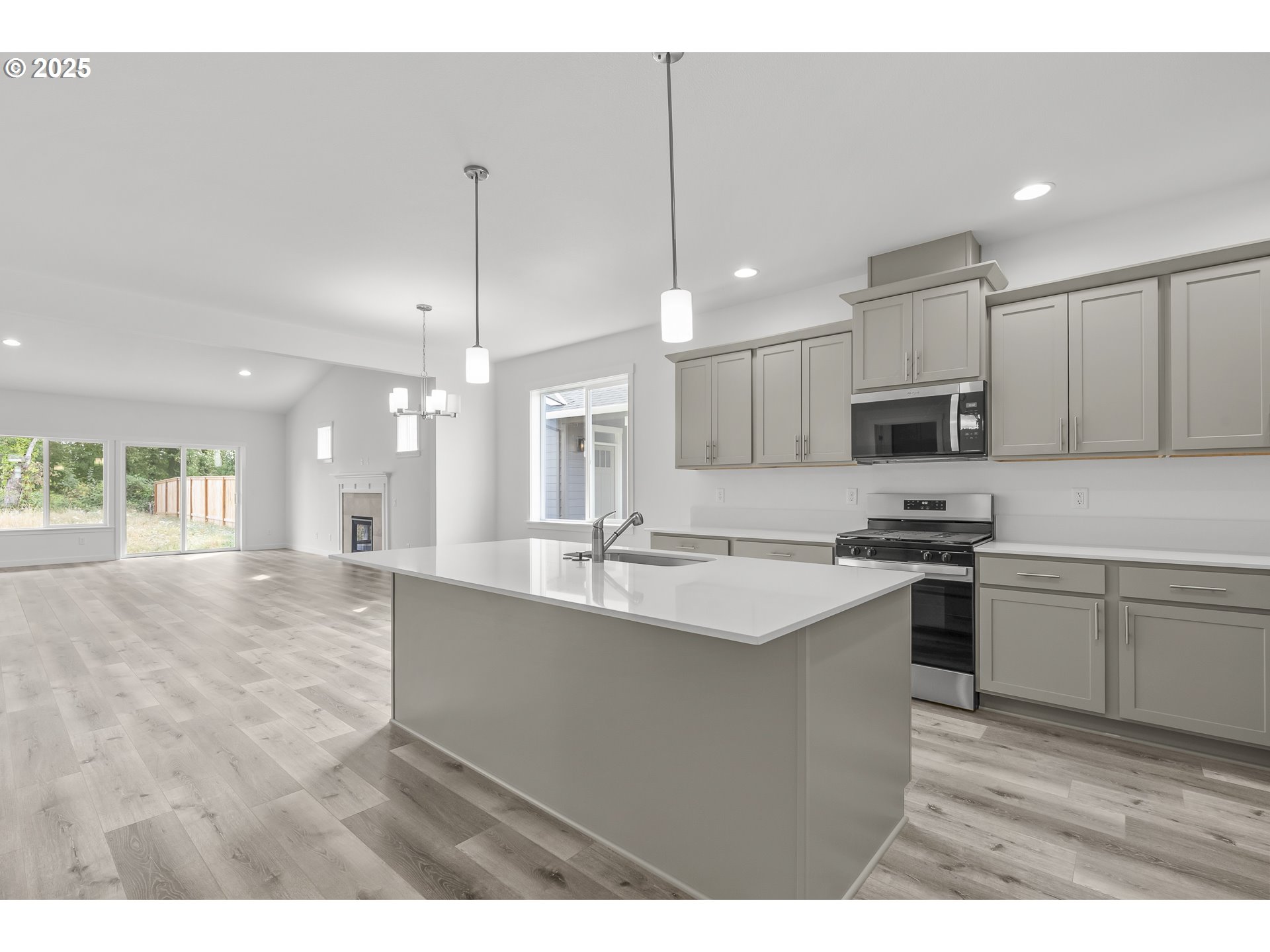 702 Tigerlily Street Silverton, OR 97381 - Photo 30 of 31 a kitchen with kitchen island a sink stainless steel appliances and cabinets