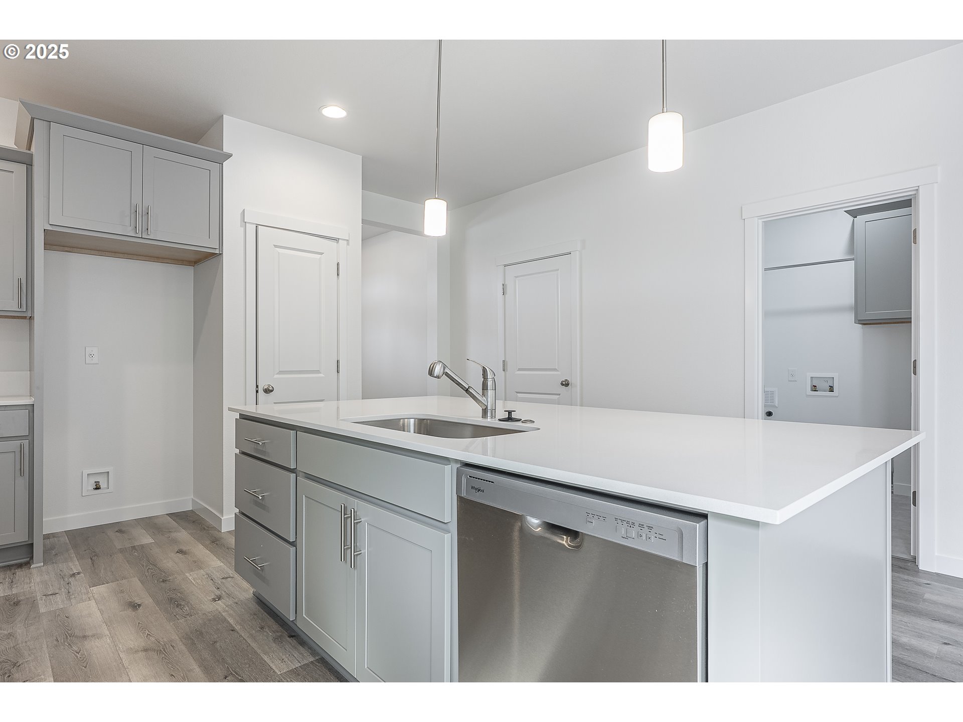 702 Tigerlily Street Silverton, OR 97381 - Photo 5 of 31 a kitchen with a sink a counter and a refrigerator