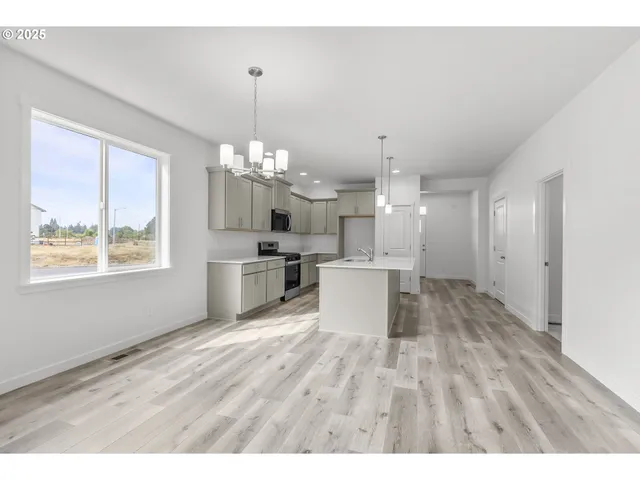 a open kitchen with kitchen island white cabinets and stainless steel appliances