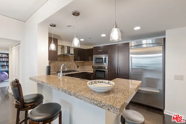 a kitchen with a dining table chairs and refrigerator