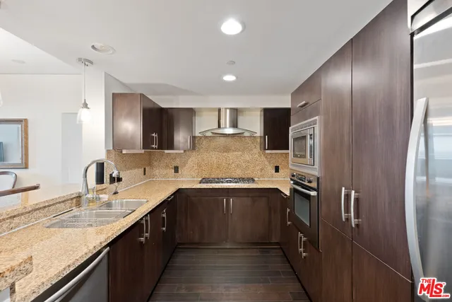 a kitchen with stainless steel appliances granite countertop a sink refrigerator and cabinets