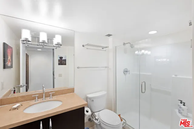 a bathroom with a sink a toilet a mirror and shower