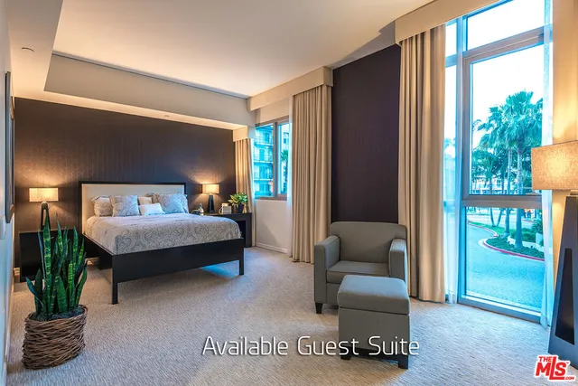 a bedroom with bed and a couch next to a window