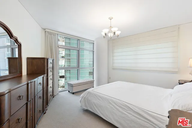 a bedroom with a large bed and a flat tv screen on dresser