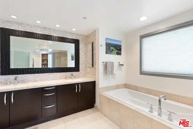 a bathroom with a tub sink and mirror