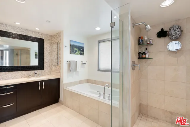 a large bathroom with a tub sink shower and mirror