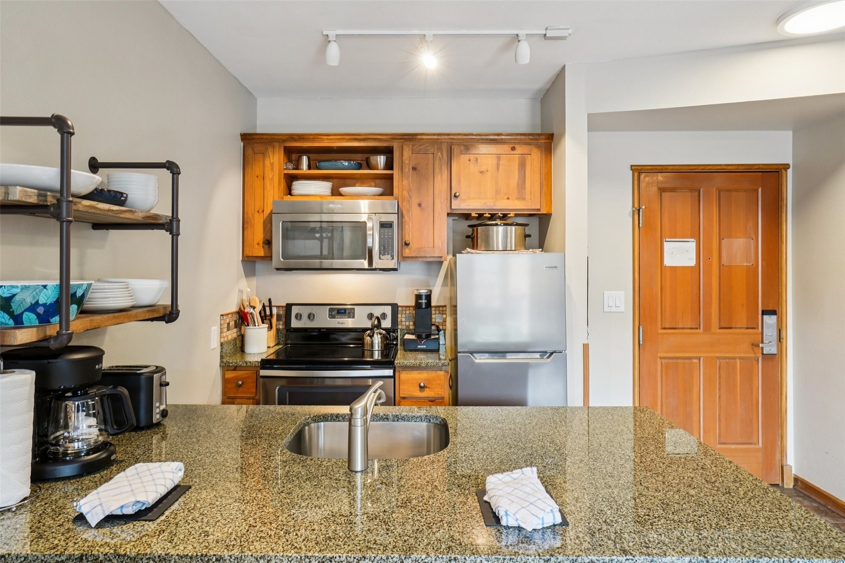 129 River Run Road, Unit 8055 Keystone, CO 80435 - Photo 5 of 50 Kitchen featuring stainless steel appliances, a sink, track lighting, open shelves, and brown cabinets