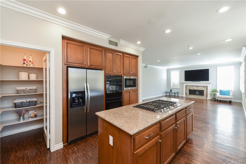 23 Benavente Irvine, CA 92606 - Photo 12 of 44 a kitchen that has a kitchen island wooden cabinets and stainless steel appliances