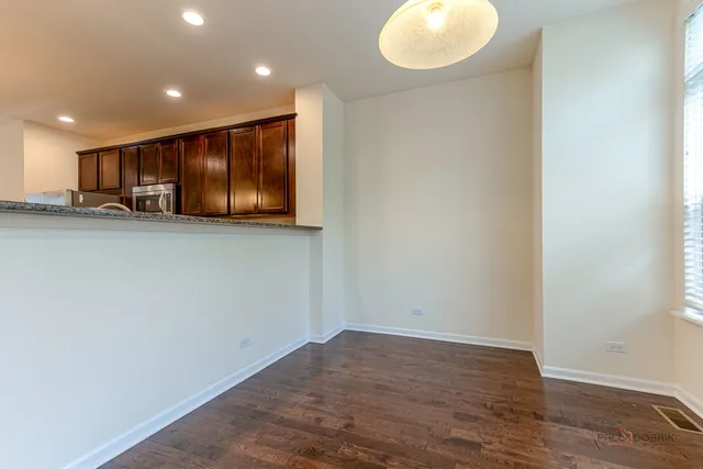 a view of kitchen with stainless steel appliances wooden floor and window