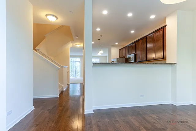 a view of a big room with wooden floor and windows