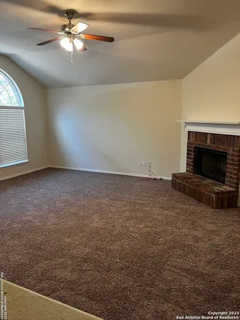 en empty room with windows and fireplace
