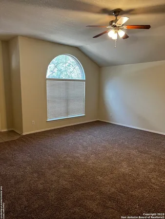 an empty room with windows and fan