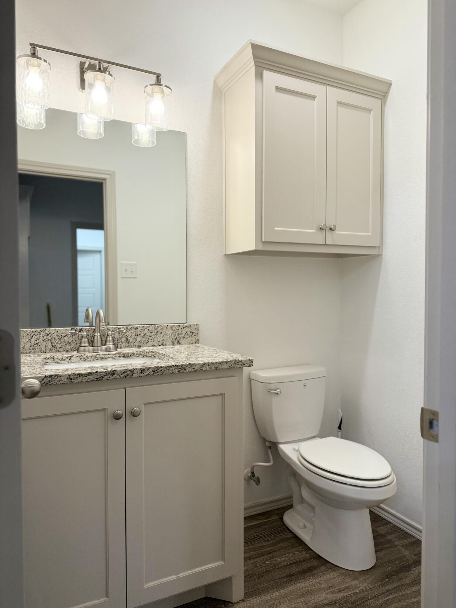 12202 Ithaca Avenue Lubbock, TX 79423 - Photo 25 of 28 a bathroom with a granite countertop toilet sink and mirror