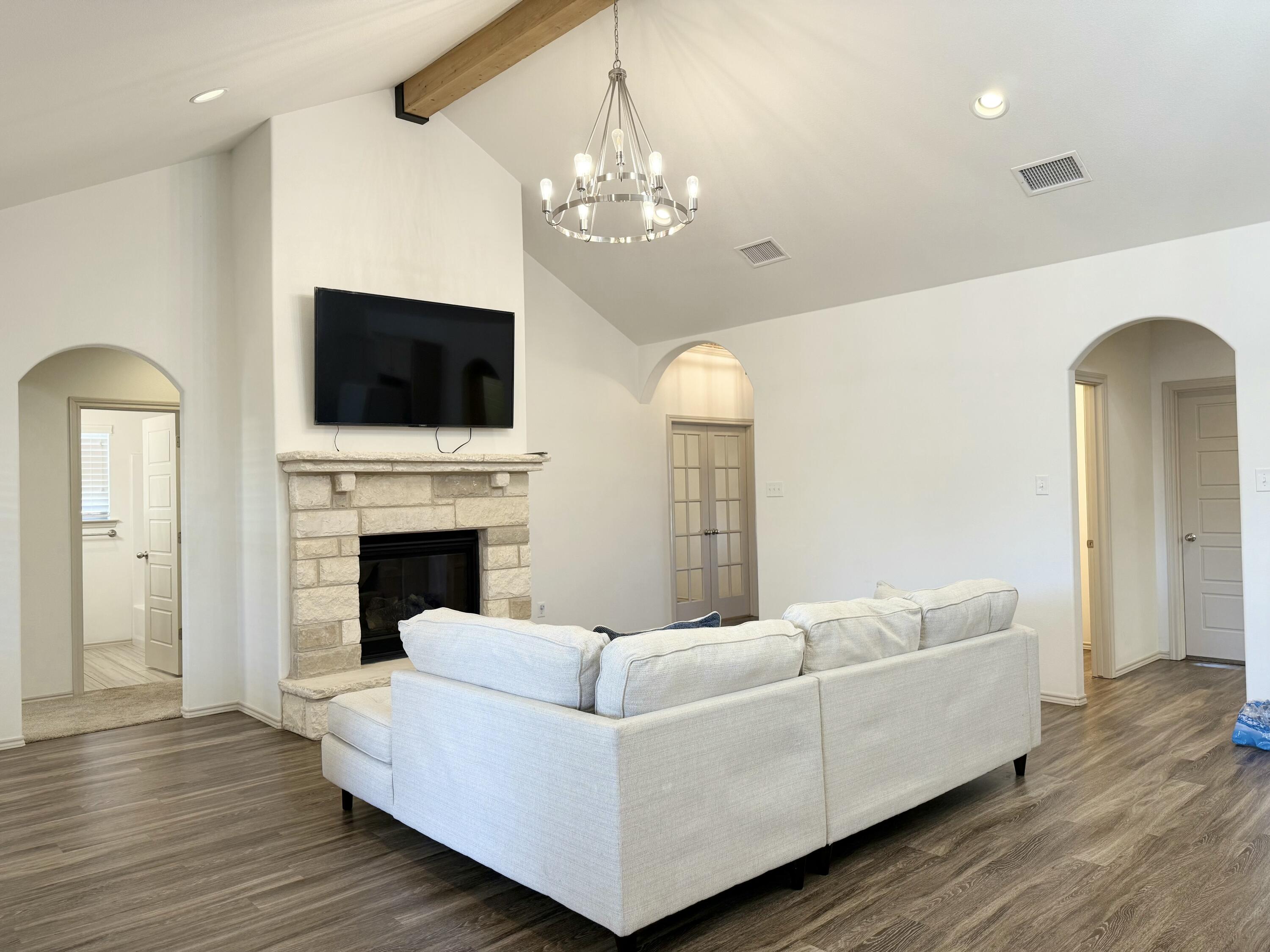 12202 Ithaca Avenue Lubbock, TX 79423 - Photo 5 of 28 a living room with furniture a fireplace and a flat screen tv