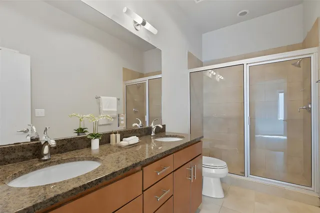 a bathroom with a granite countertop sink toilet and shower
