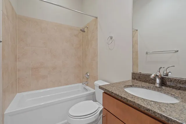 a bathroom with a granite countertop sink toilet and shower