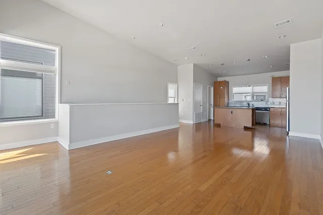 a view of a kitchen with wooden floor and a window