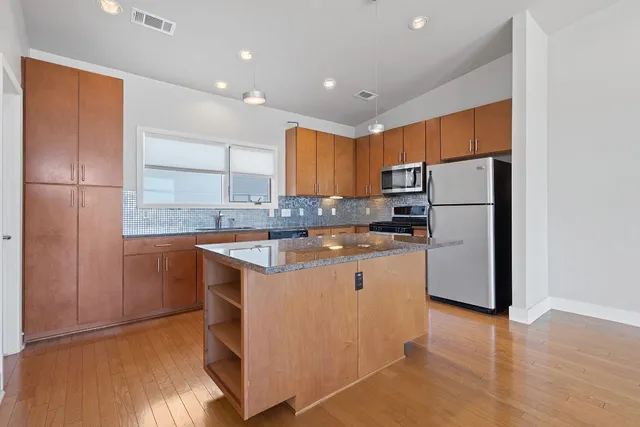 a kitchen with stainless steel appliances granite countertop a refrigerator sink and cabinets