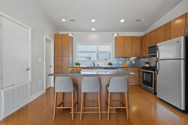 a kitchen with a table chairs refrigerator and microwave