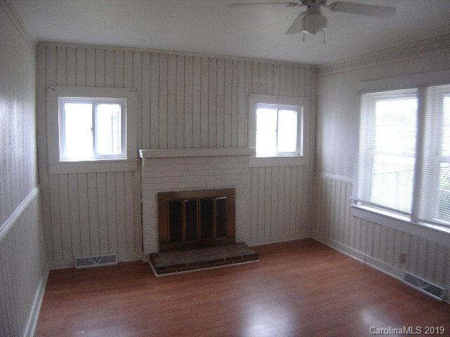 575 State Street Marion, NC 28752 - Photo 8 of 18 an empty room with windows fireplace and fan