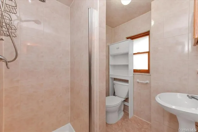 a white toilet sitting next to a bathroom sink and tub