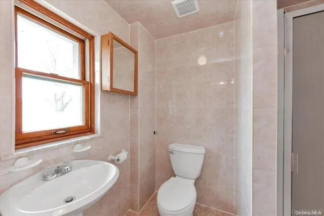 a bathroom with a toilet sink and a mirror