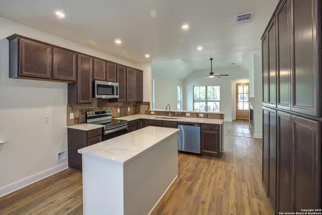 a kitchen with a sink stove top oven and refrigerator
